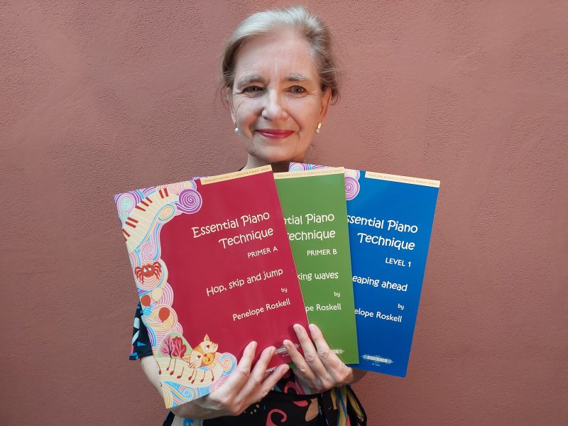 piano teacher holding books, teaching piano to children, piano books for kids, piano books for children and young learners
